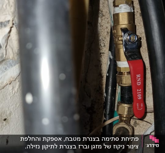 שסתום פליז עם ידית אדומה בצנרת מים